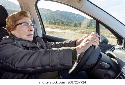 Older Woman Driving A Car, On A Sunny Day.