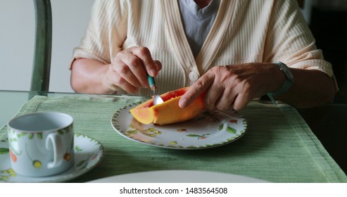 Older Woman Eating Breakfast Papaya Fruit In The Morning