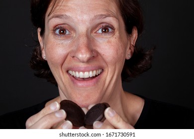 Older Woman Eating A Chocolate Cream Filled Cookie. Unhealthy Lifestyle Junk Food Concept.