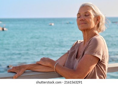 Older Woman Enjoying The Peace Of The Sunset And The Sea Breeze In Summer.