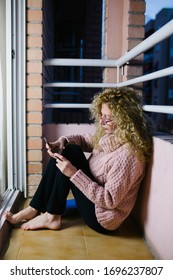 An Older Woman With Glasses Sitting On The Balcony Floor Using Her Phone During The Crown Virus Quarantine