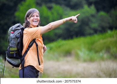 Older Woman Is Hiking In Nature And Pointing To Something