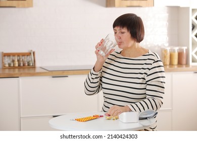 Older Woman Hold Glass Of Water And Antibiotic Aspirin Pill Feel Unhealthy At Home, Sick Mature Female Take Daily Dose Of Supplements Or Vitamins, Elderly Healthcare Concept.