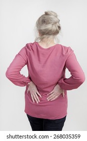 An Older Woman Holds Her Back In Pain