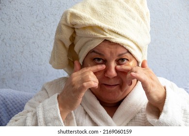 Older Woman Holds Patches Glued To Her Face With Her Fingers. Selective Focus. A Picture For Articles About Age-related Facial Care.