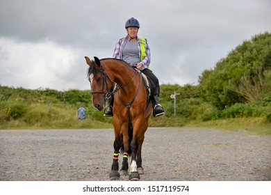 Older Woman On  Her Horse Smiling At The Camera. 