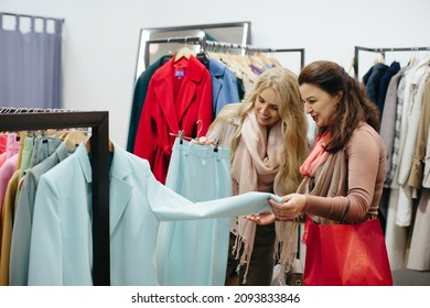 Older Woman Picking Clothes In A Store.