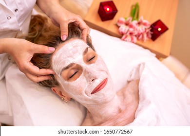 Older Woman With Piercings Wearing Beauty Face Mask On A Massage Table