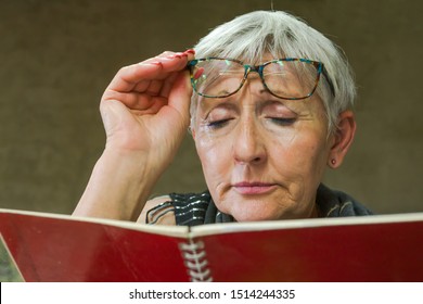 Older Woman With Visión Problems,trying To Read A Book