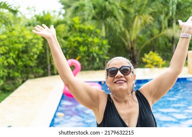 Older Woman In The Rain By The Swimming Pool