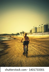 Older Woman Ride Bike Along Beach