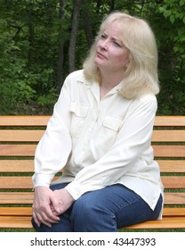 Older Woman Sitting On A Park Bench