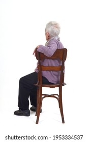 An Older Woman Sitting In Profile And Looking Back On White Background