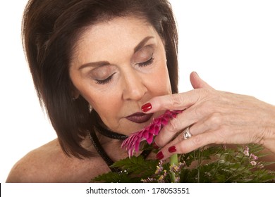 A Older Woman Smelling The Beautiful Flowers.