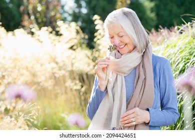 Older Woman Smelling Flowers Outdoors
