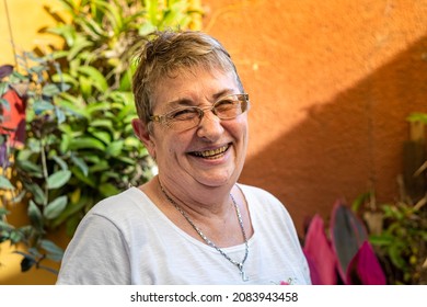 Older Woman Smiling Exaggeratedly In The Garden.