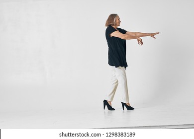 Older Woman With Straightened Arms And High Heels Walks To The Side, Side View            