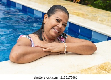 Older Woman In Swimsuit Standing In The Pool On Summer Vacation.