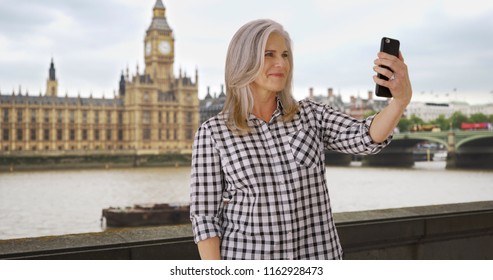 Older Woman Traveling In London Takes A Selfie On Her Smartphone