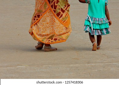 Older Woman Walking Together With Her Daughter Barefoot On Indian Street  