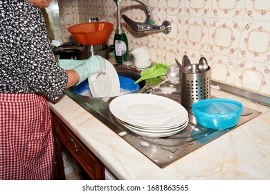 Older Woman Washing Silverware After Dinner