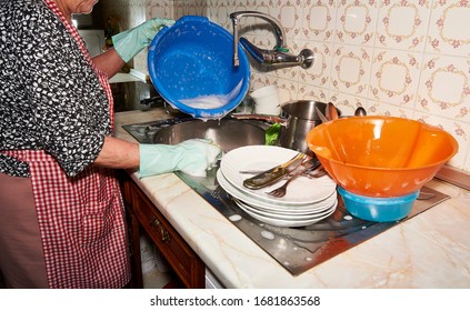 Older Woman Washing Silverware After Dinner