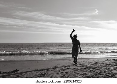 An Older Woman Wearing Gloves Is Exercising On The Beach During Winter 