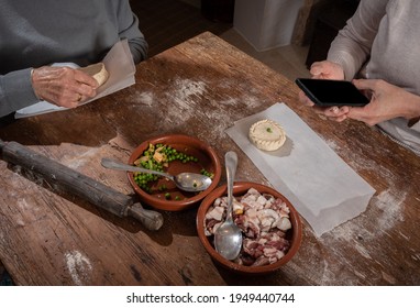 Older Woman And Young Woman Making Traditional Mallorcan Empanadas. Mallorcan Empanadas. Easter Traditions. Hands Doing Culinary Activities.