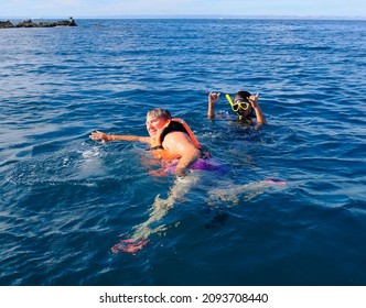 Older Woman And Young Man Snorkeling In The Ocean