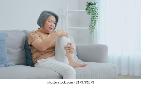 Older Women Are Hurting Their Legs. She Felt A Lot Of Pain. The Back Of The Leg Hit The Table. Woman Sitting On The Sofa At Home