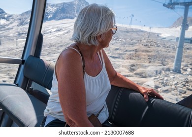 Older women looking out from inside a cablecar in the alps, picture from kitzsteinhorn area Austria.Focus on foreground.