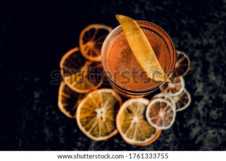 old-fashioned cocktail with orange peel in beautiful glasses on a dark background