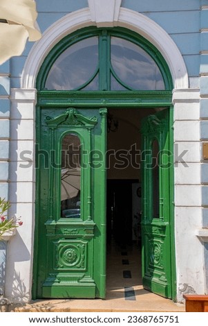 Oldfashioned green wooden front door with transom window