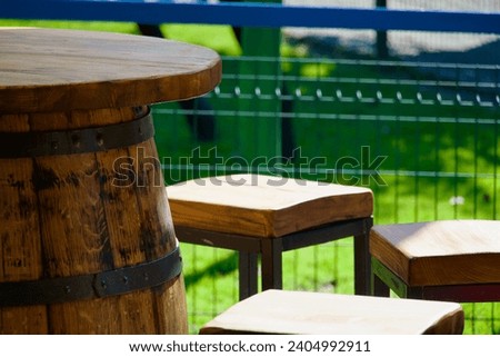Old-fashioned retro restaurant interior. Vintage style wooden barrel as table and stools. Traditional cellar furniture in rundown pub outdoors. Brown old antique empty chair. Rustic bar in countryside