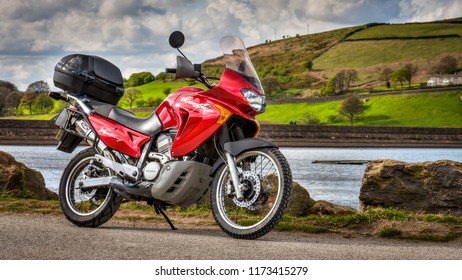 Oldham, UK, April 29, 2015: Red Honda Transalp XLV650 Motorbike With Countryside Background