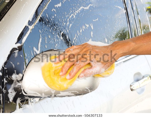 Oldman washing car at home. Cleaning car.\
Closeup hand use yellow sponge washing\
car.