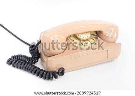 Oldschool pink telephone on a white background. Telecommunication. Vintage objects.