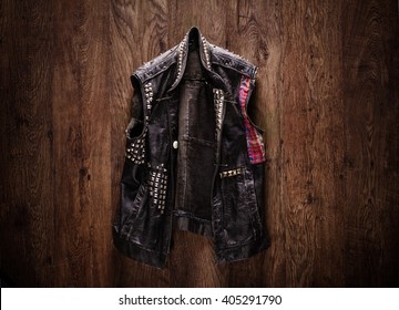 Old-school punk-rock leather jacket hanging on a wooden background - Shutterstock ID 405291790