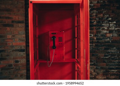 Oldschool red payphone inside vintage red telephone booth