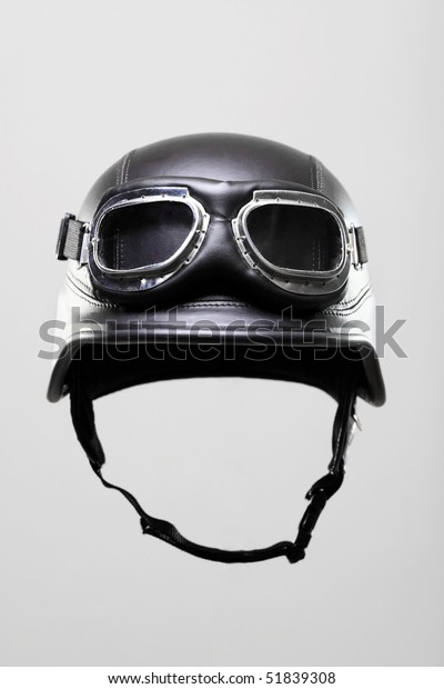 old-style us army motorcycle helmet with\
goggles, floating on gray\
background