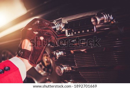 Oldtimer Driver Changing Radio Station Inside His Vintage Classic Car Close Up. Automotive Theme.