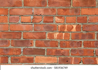 Old,weathered red brick background with uneven shapes and sizes of brick 