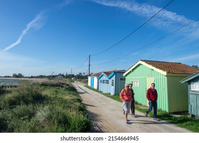 Oleron Island, Charente-Maritime,  France : September 25th 2015. Oyster farming site with tourists walking on coastal path beside colourful fishing sheds