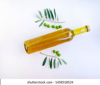  Olive Oil Bottle And Fresh Cuted Branch Of Olive Tree On The White Table. Top Of View.