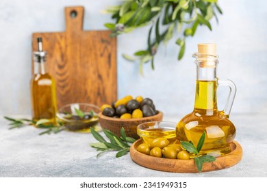 Olive oil in a bottle and gravy boat on the kitchen table. Oil bottle with branches and fruits of olives. Place for text. copy space. vegetable oil and salad dressing. - Powered by Shutterstock