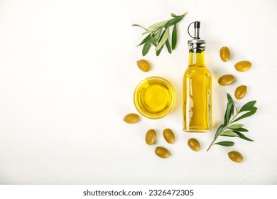 Aceite de oliva en una botella sobre fondo de textura blanca. Botella de aceite con ramas y frutos de aceitunas. Colocar el texto. espacio de copia. aceite de cocina y aderezo de ensalada.