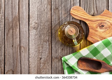 Olive Oil Bottle And Utensils On Wooden Table. Top View With Copy Space