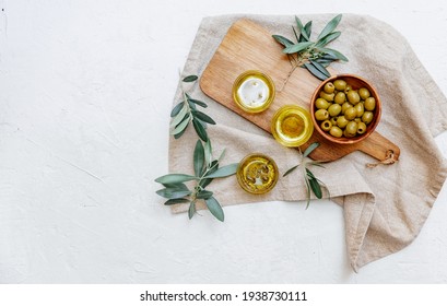 Olive oil and bread fresh branch of olives on white marble background directly above.Testing fresh olive oil. Arkivfotografi