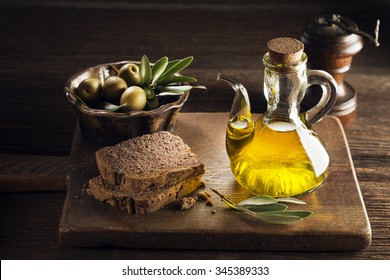 Olive Oil With Bread On A Wooden Table.