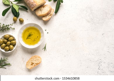 Olive Oil and Bread. Organic olive oil with green olives in bowl, herbs and ciabatta bread on white background with copy space, healthy mediterranean food concept. - Powered by Shutterstock